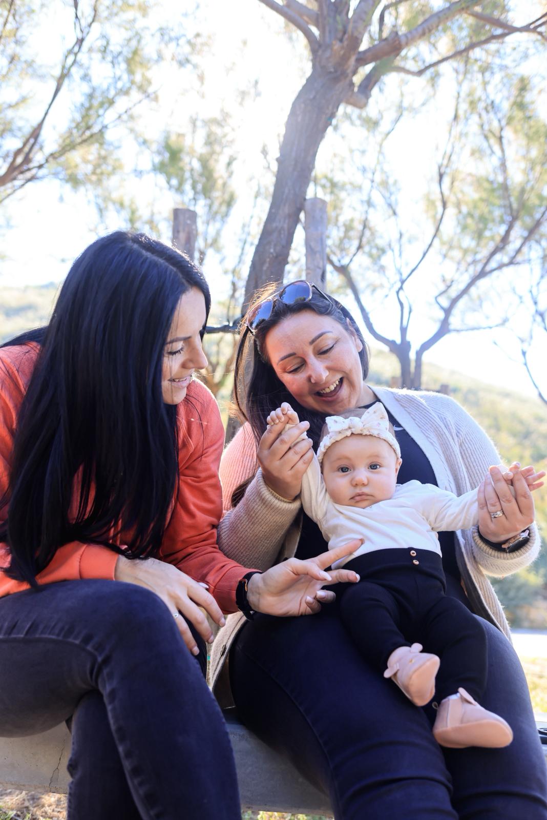 Mother and baby smiling outdoors